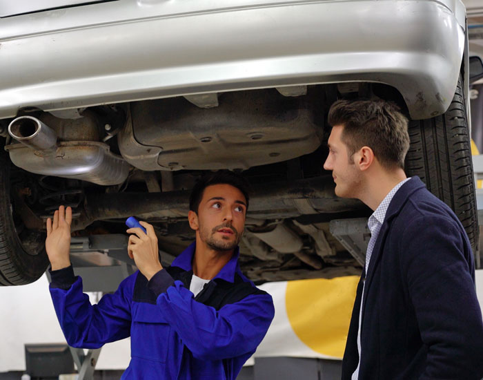 two men looking under car